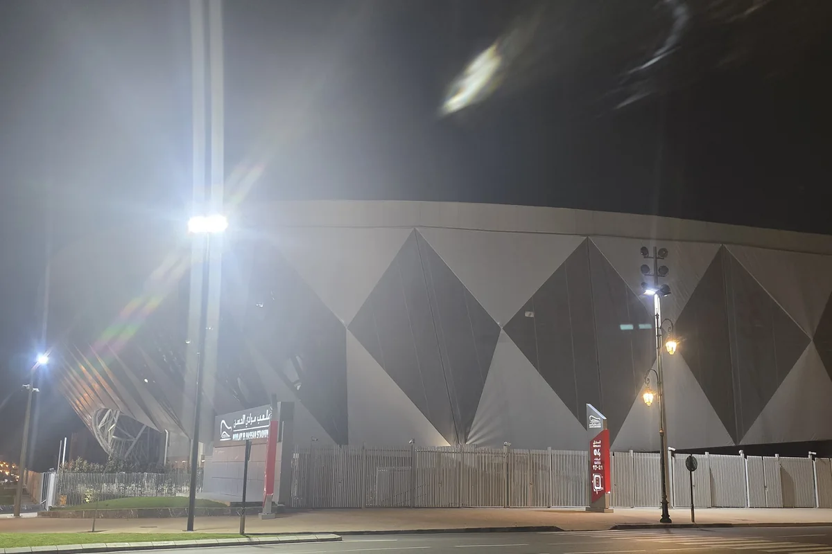 The illuminated exterior of Moulay El Hassan Stadium in Rabat at night.